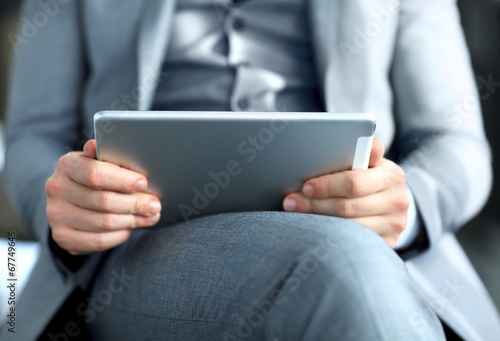 Photo: Young adult working on a digital tablet Young adult working on a digital tablet