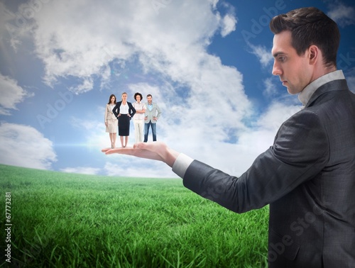 Photo: Composite image of businessman holding business team Composite image of businessman holding business team