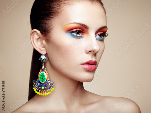 Photo: Portrait of beautiful young woman with earring. Jewelry and acce Portrait of beautiful young woman with earring. Jewelry and acce