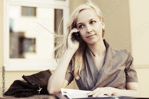 Photo: Blond fashion business woman calling on the cell phone Blond fashion business woman calling on the cell phone