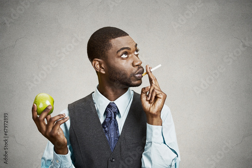 Photo: Man smoking cigarette, instead of making healthy choices Man smoking cigarette, instead of making healthy choices