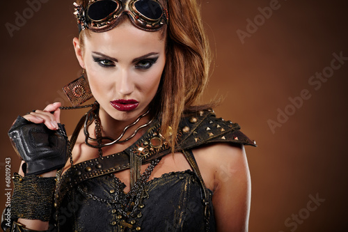 Photo: Steampunk woman over gunge background. . Fantasy fashion for cov Steampunk woman over gunge background. . Fantasy fashion for cov