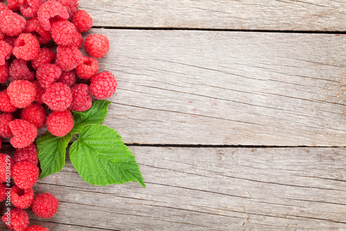 Photo: Fresh ripe raspberries on wooden table Fresh ripe raspberries on wooden table