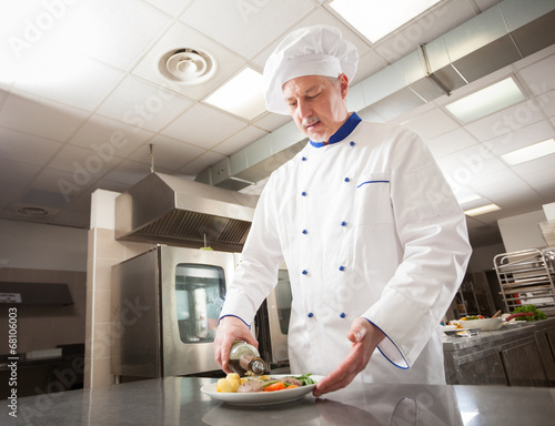 Photo: Male chef decorating a dish Male chef decorating a dish