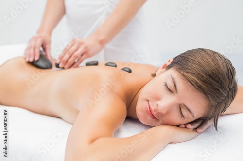 Photo: Beautiful woman receiving stone massage at spa center Beautiful woman receiving stone massage at spa center
