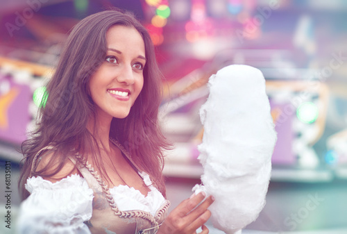 Photo: German Girl wearing a Dirndl and eating candyfloss German Girl wearing a Dirndl and eating candyfloss