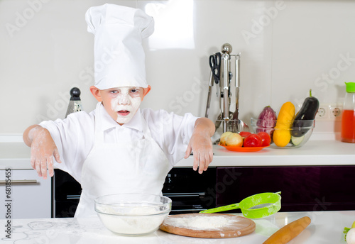Photo: Cute little boy chef in the kitchen Cute little boy chef in the kitchen