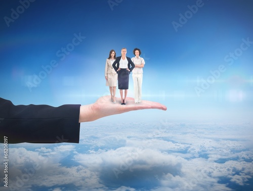 Photo: Composite image of team of businesswomen looking at camera Composite image of team of businesswomen looking at camera