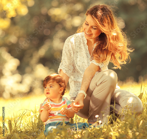 Photo: Mother and baby girl sitting and relaxing in nature. Mother and baby girl sitting and relaxing in nature.
