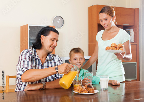 Photo: couple with teenager son having breakfast in home couple with teenager son having breakfast in home