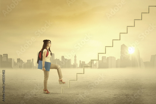 Photo: Female student is climbing stair Female student is climbing stair