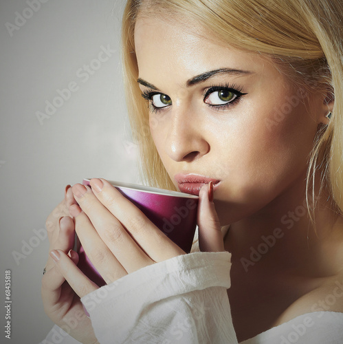 Photo: Beautiful woman drinking Coffee.Cup of tea.Hot drink.Blond Girl Beautiful woman drinking Coffee.Cup of tea.Hot drink.Blond Girl