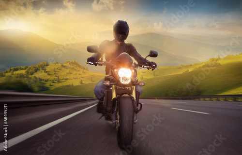 Photo: Man seat on the motorcycle on the mountain road Man seat on the motorcycle on the mountain road
