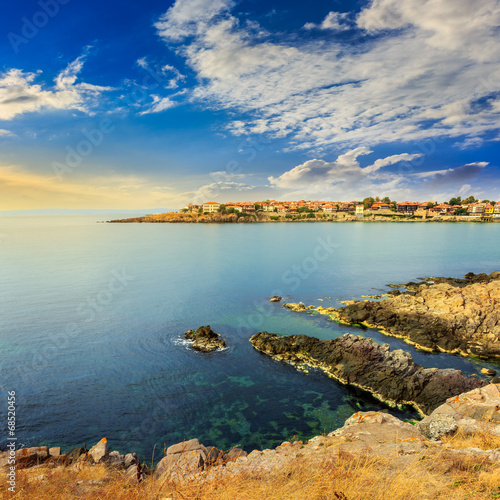 Photo: ancient city on a rocky shore near sea at sunrise ancient city on a rocky shore near sea at sunrise