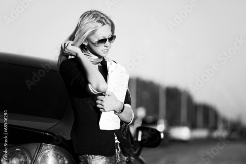 Photo: Fashion business woman with financial papers at the car Fashion business woman with financial papers at the car