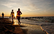 Friends walking on the beach at sunset Friends walking on the beach at sunset