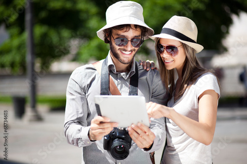 Photo: Couple of tourists using a digital tablet Couple of tourists using a digital tablet