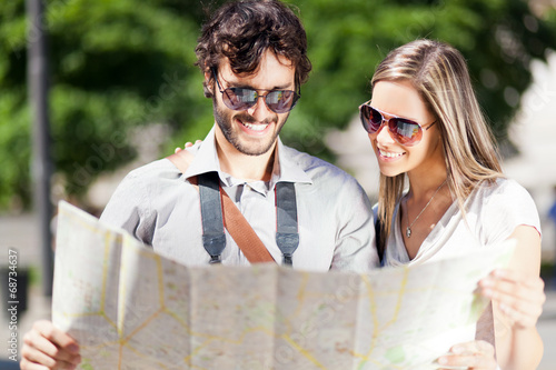 Photo: Happy tourists couple holding map Happy tourists couple holding map