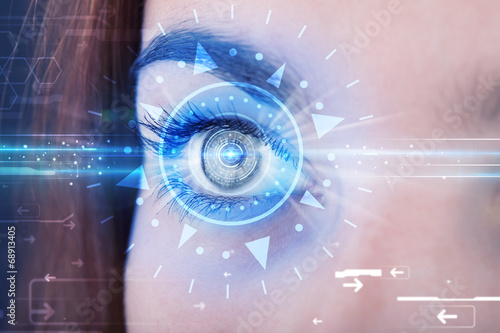 Photo: Cyber girl with technolgy eye looking into blue iris Cyber girl with technolgy eye looking into blue iris