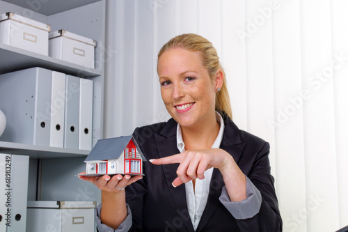 Photo: Immobilienmaklerin in ihrem Büro Immobilienmaklerin in ihrem Büro