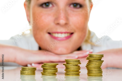 Photo: Frau mit Münzstapel beim Geld sparen Frau mit Münzstapel beim Geld sparen