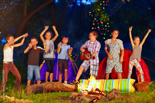 Photo: happy kids dancing around campfire happy kids dancing around campfire