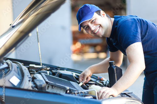Photo: Professional car mechanic working in auto repair service. Professional car mechanic working in auto repair service.