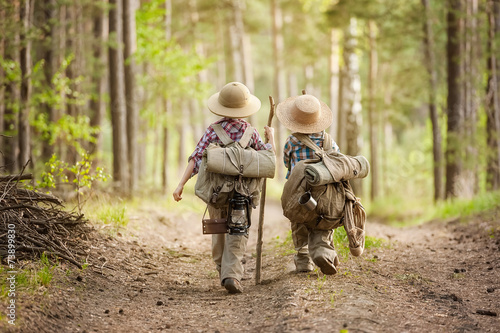 Boys on a forest road with backpacks