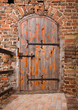 Old wooden door in brick wall of castle Old wooden door in brick wall of castle