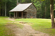 Old log farmhouse with a dirt path Old log farmhouse with a dirt path