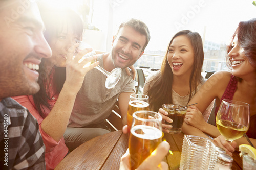 Group Of Friends Enjoying Drink At Outdoor Rooftop Bar