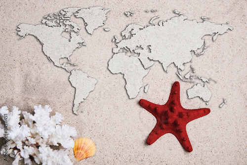 Map of the world. Traveling concept. Starfish with coral on the Beach sand
