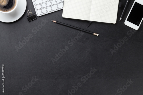 Office leather desk with computer, supplies and coffee
