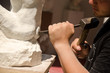 Man with hammer working on stone statue Man with hammer working on stone statue