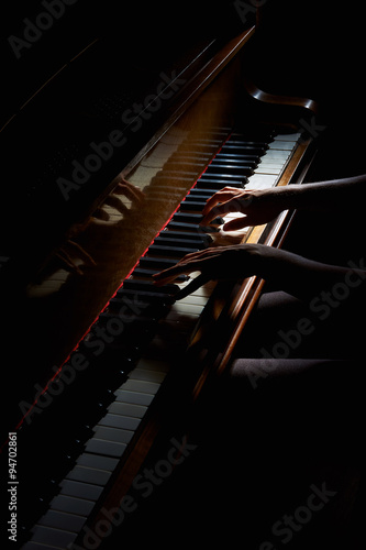 Fototapeta na wymiar Woman's hands on the keyboard of the piano in night closeup