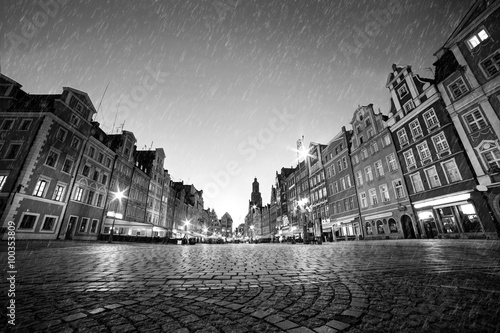 Fototapeta Cobblestone historic old town in rain at night. Wroclaw, Poland. Black and white