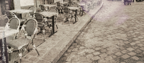 Fototapeta Outdoor restaurant tables in Paris, vintage view