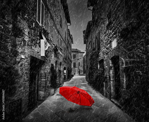 Umbrella on dark street in an old Italian town in Tuscany, Italy. Raining.