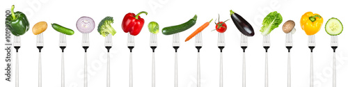  row of tasty vegetables on forks isolated on white background
