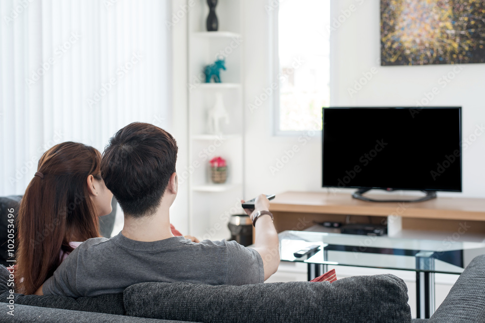 Young Asian couple waching movie on tv at home