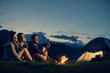 Three friends camping with fire on mountain at sunset Three friends camping with fire on mountain at sunset