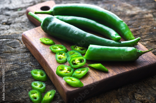 Fresh green chilli on old wooden background