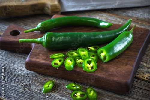 Fresh green chilli on old wooden background