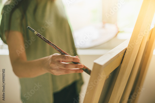 Cropped shot of artist makes paint brush strokes on canvas