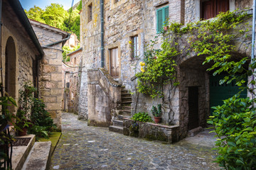Spring streets of the old Tuscan town. Colorful flowers bloom an