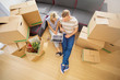 Couple sitting on floor surrounded with moving boxes and using computer Couple sitting on floor surrounded with moving boxes and using computer