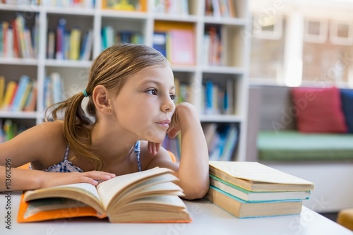 Fotoobraz na płótnie Rozważnej szkolnej dziewczyny czytelnicza książka w bibliotece
