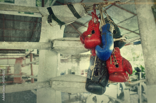 Zdjęcie XXL Para starych bokserskich rękawic Muay Thai wisi na ringu w obozie slumsów. Dodany efekt dodania do stworzenia atmosfery