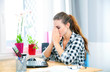 Stressed and thinking woman in home office using laptop Stressed and thinking woman in home office using laptop