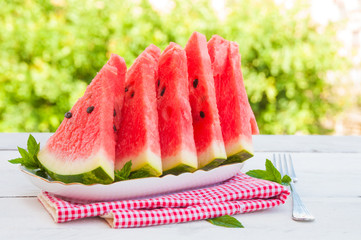 Slices of watermelon in a plate on wooden table